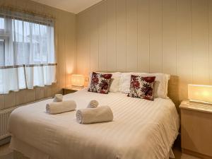 a bedroom with a large bed with two pillows on it at Grandma's Stick House in West Down