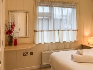 a bedroom with a bed and a window at Grandma's Stick House in West Down