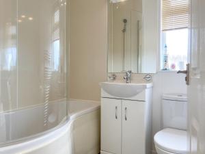 a bathroom with a sink and a tub and a toilet at Grandma's Stick House in West Down +9 photos