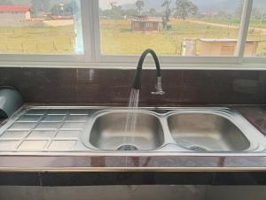 a kitchen sink with water running from a faucet at Casa campo in Oxapampa