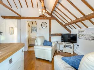 a living room with a couch and a tv at Walker's Retreat - Uk45415 in Eaton Bishop