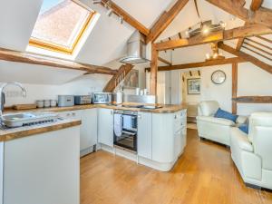 a kitchen and living room with wooden ceilings at Walker's Retreat - Uk45415 in Eaton Bishop