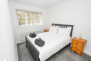 a bedroom with a large white bed and a window at Modern 2-Bed Home with Driveway – Basingstoke in Sherborne Saint John