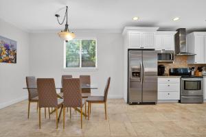 eine Küche mit einem Tisch mit Stühlen und einem Kühlschrank in der Unterkunft Fort Lauderdale Villa Private Pool - Rooftop in Fort Lauderdale