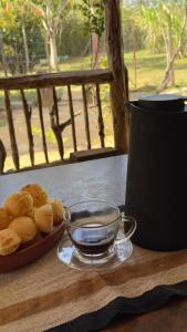 un plato de pan y una taza de té sobre una mesa en Pouso campestre Ohana para família em Tiradentes, en Tiradentes