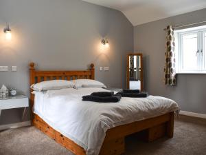 a bedroom with a large bed with two towels on it at Owl Cottage in Ryton +4 photos