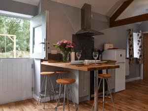 a kitchen with a island with bar stools at Owl Cottage in Ryton