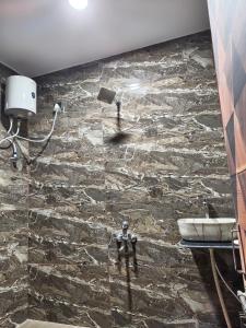 a stone bathroom with a sink and a stone wall at Virasat Villa in Mount Ābu