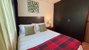 a bedroom with a bed with a plaid blanket at Casa Boutique Familia Hurtado in Manizales