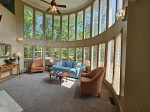 een woonkamer met een blauwe bank en een heleboel ramen bij 21A Edelweiss in Chalet Village