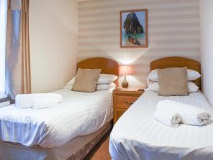two twin beds in a room with a window at 7 Oaklands in Ambleside