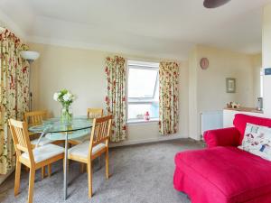 ein Wohnzimmer mit Tisch und Couch in der Unterkunft Carraig Dhubh Cottage - Uk47123 in Whiting Bay