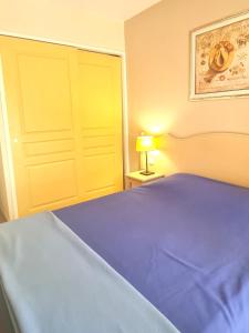 a bedroom with a blue bed and a yellow door at Apartment with view in Roquebrune-sur-Argens in Roquebrune-sur-Argens