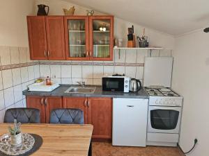 a kitchen with a white stove and a microwave at Ana & Stela in Karlobag