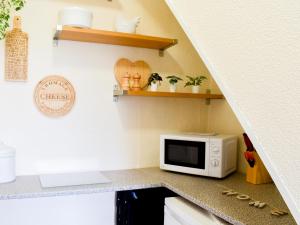 a kitchen with a microwave on a counter at Ivy Cottage in Newchurch +13 photos