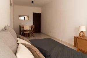 a living room with a couch and a table at Apartamento completo com garagem a 150 m da praia in Praia Grande