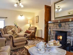 sala de estar con chimenea y espejo en Priory Barn, en Burscough