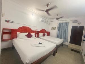 a bedroom with two beds and a ceiling fan at VR Jardin Resort in Pondicherry