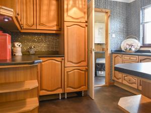 a kitchen with wooden cabinets and a counter top at Kimberley Bungalow in Alness