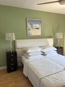 a bedroom with a large white bed with two lamps at Villa Plein Soleil in Sarrians +21 photos
