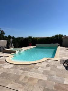 a swimming pool in a yard with a tile patio at Villa Plein Soleil in Sarrians