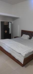Un dormitorio con una cama grande con sábanas blancas. en DishaHomeStay khajuraho, en Khajurāho