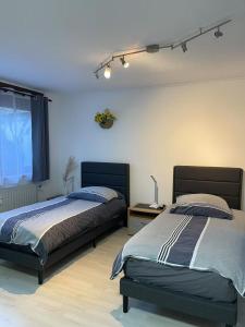 ein Schlafzimmer mit zwei Betten und einem Fenster in der Unterkunft Düsseldorf Messe, 2-bedroom Duplex Apartment with Terrace and Garden in Düsseldorf