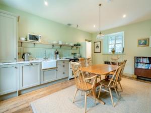 une cuisine avec une table et des chaises en bois dans l'établissement Uk47813 - Cooks Cottage, à Kinloch Rannoch