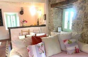 a living room with a white couch with pillows at Country House Ca di siro in Gazola