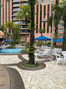 a courtyard with tables and chairs and a palm tree at Times Square KL Serviced Suite in Kuala Lumpur