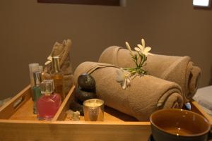 a wooden tray with towels and cosmetics on a table at Red River Retreat in Hatikhuli