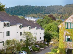 una fila de casas con un río en el fondo en High Brow, en Bowness-on-Windermere