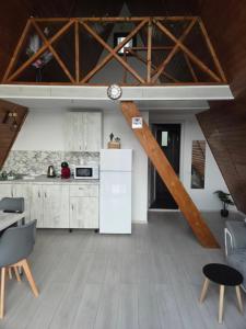a kitchen with white appliances and wooden ceilings at A-frame Muchia Scortii in Şimon
