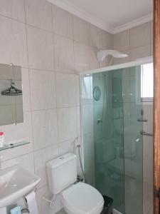 a bathroom with a toilet and a glass shower at Garcida in Governador Celso Ramos