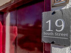 un cartel en un edificio con el número en él en 19 South Street, en Grantown-on-Spey