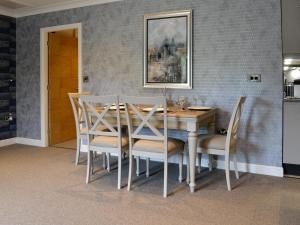 a dining room with a wooden table and chairs at Fernhill Cottage in Oxenhope
