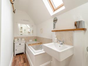 ein weißes Badezimmer mit Waschbecken und Spiegel in der Unterkunft Stoney Cottage in Loftus + 9 Fotos