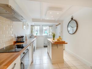 eine Küche mit weißen Schränken und einer Arbeitsplatte in der Unterkunft Stoney Cottage in Loftus