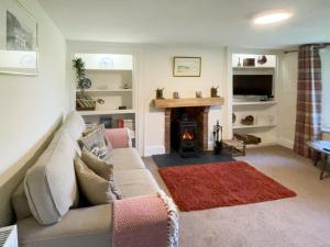 a living room with a couch and a fireplace at Court End Cottage in Silecroft