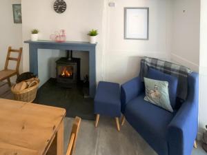 a living room with a blue couch and a fireplace at Court End Cottage in Silecroft +41 photos
