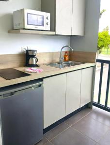 a kitchen with a sink and a microwave at Golf Marin in Saint-François +1 photo