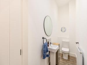 a white bathroom with a sink and a mirror at Weaver's Snug in Haworth +13 photos