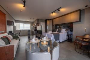 a hotel room with a bed and a living room at Excelente Apto Moderno e espaçoso no Cittyplex Osasco in Osasco