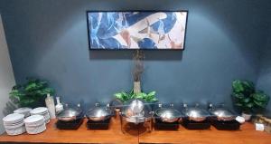 a table with bowls and plates and a tv on a wall at Crowne Plaza Orlando-Downtown by IHG in Orlando