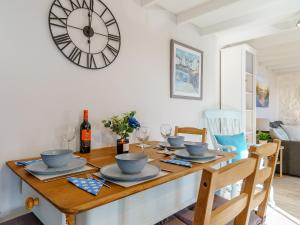 a dining room with a table with a clock on the wall at Bon Accorde in Goodwick