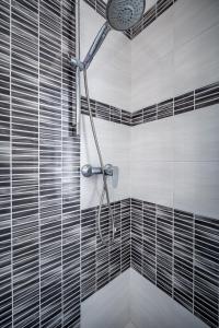 a shower in a bathroom with black and white tiles at YD penthouse Torregalli in Scandicci +17 photos