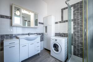 a white bathroom with a washing machine and a sink at YD penthouse Torregalli in Scandicci