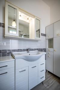 a white bathroom with a sink and a mirror at YD penthouse Torregalli in Scandicci