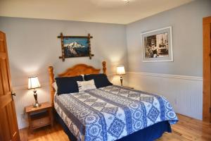 a bedroom with a bed with a blue and white comforter at The McCloud Vacation Home on Mt Shasta, Sleeps 13 in McCloud