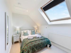 ein Schlafzimmer mit einem Bett und einem Dachfenster in der Unterkunft The Owl Barn - Uk48736 in Gaerwen